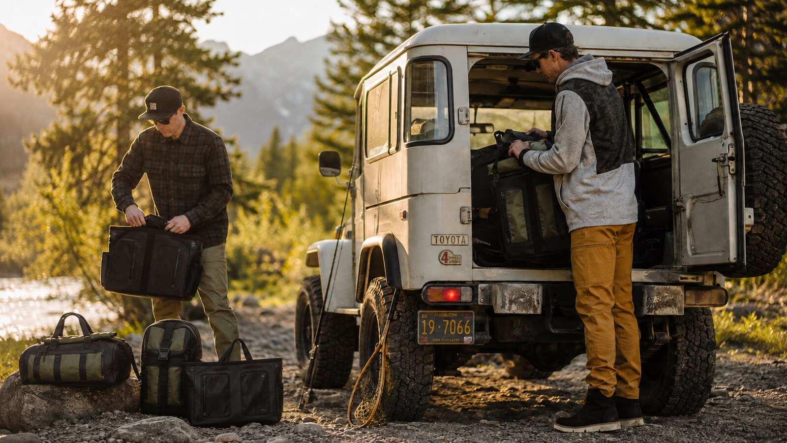 Terrascout lifestyle image of two rugged male models loading bags beside a vintage FJ40 for a fishing trip at golden hour.