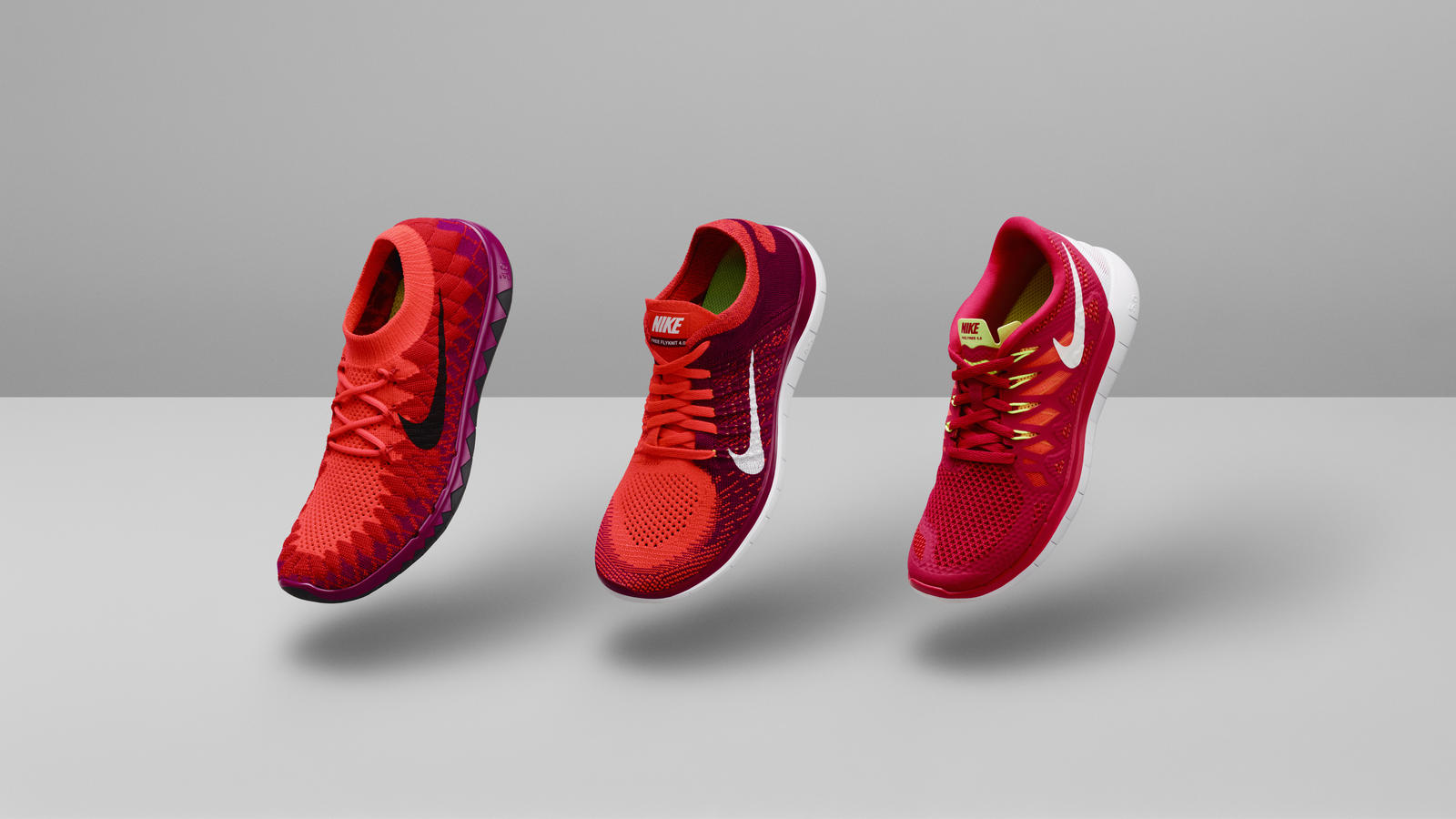 Official 2014 Nike Free women’s lineup: 3.0 Flyknit, 4.0 Flyknit and 5.0, left to right, in red and pink against a gray studio background.