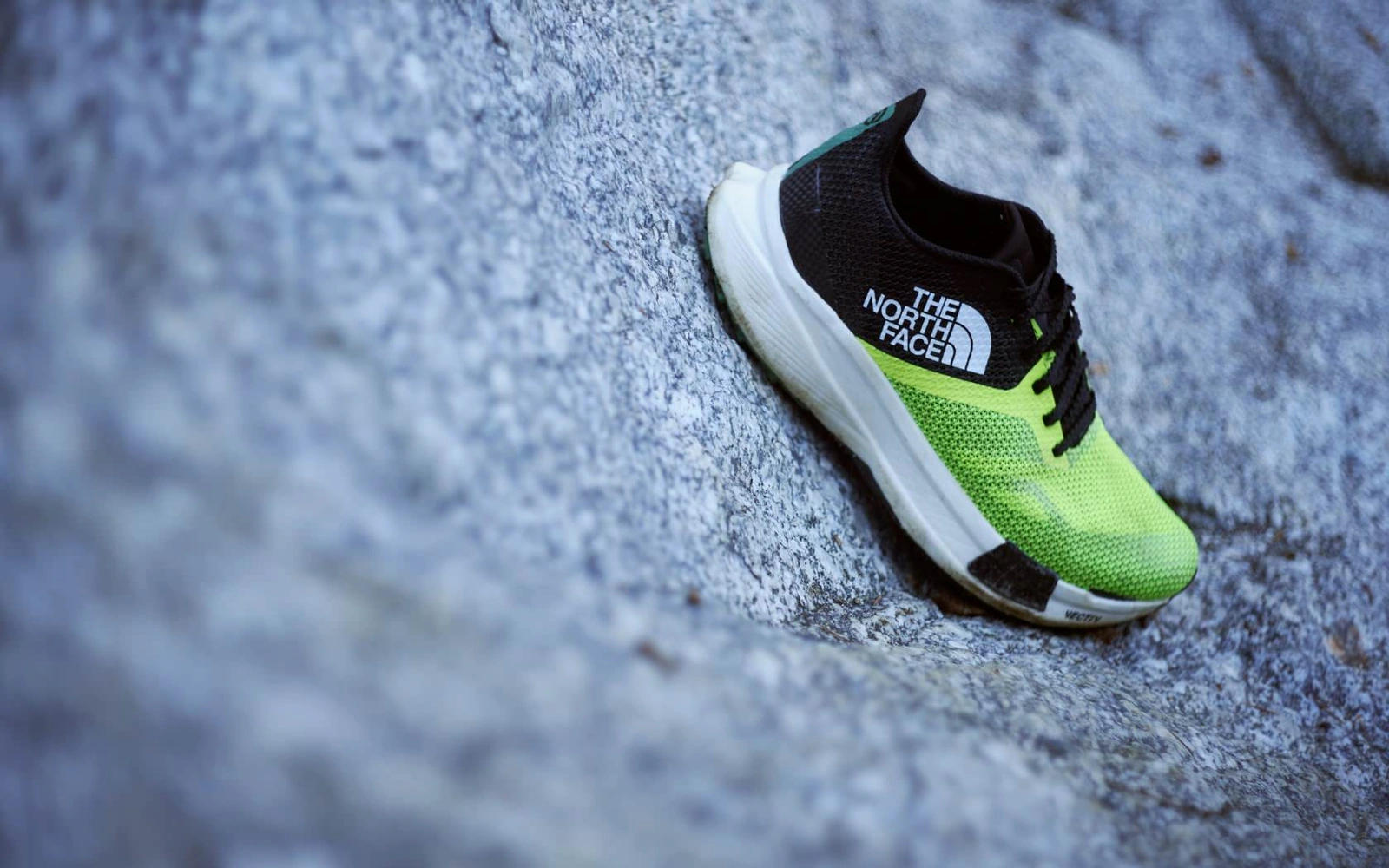 Black and fluorescent yellow Summit VECTIV Pro shoe photographed on rock.