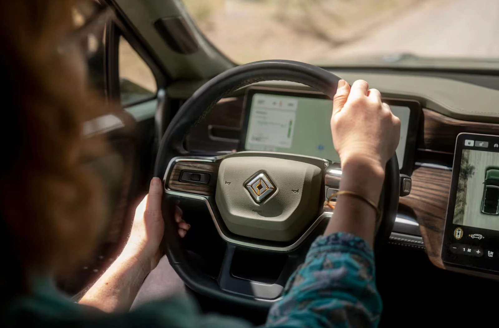 Driver view of the Rivian steering wheel, center display and digital vehicle interface.