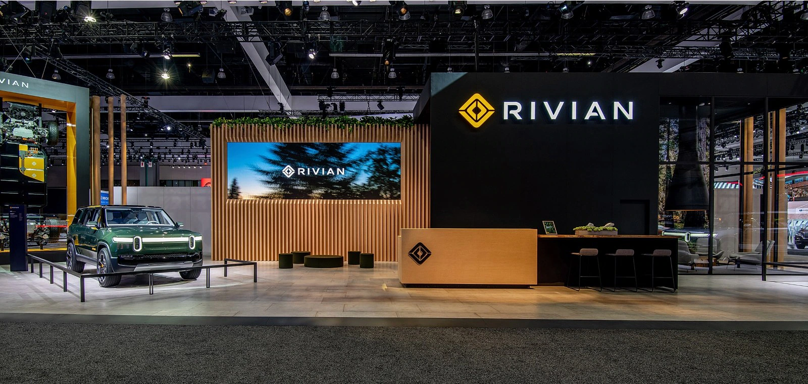 Rivian auto show environment with an R1S and reception area.