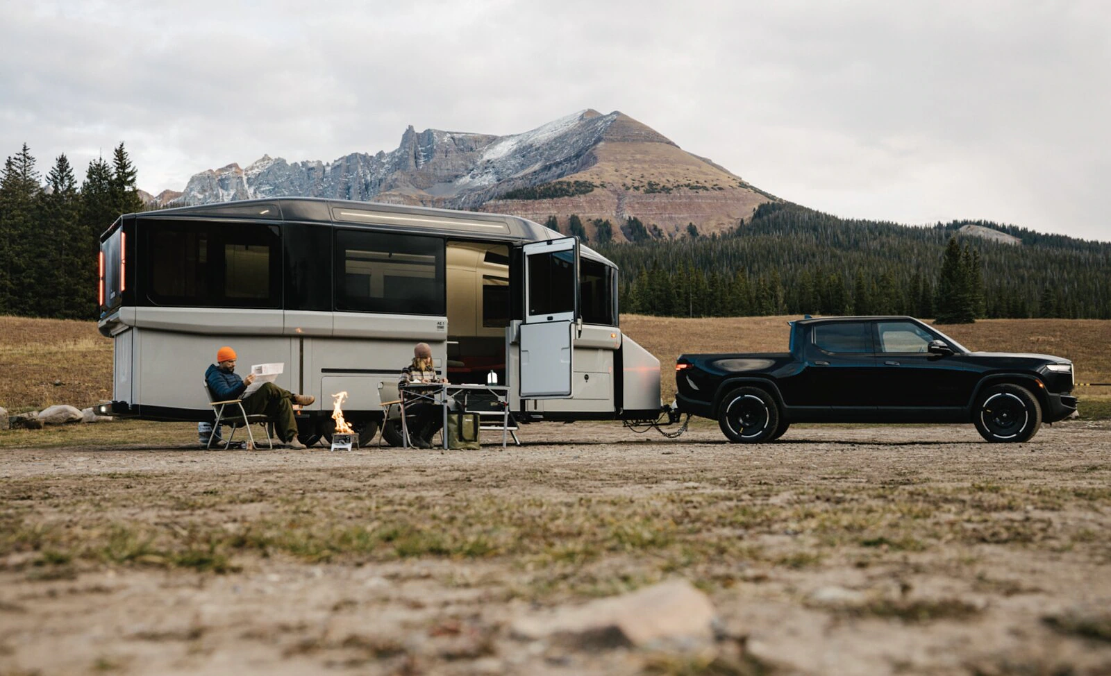 Lightship travel trailer and tow vehicle at a mountain campsite.