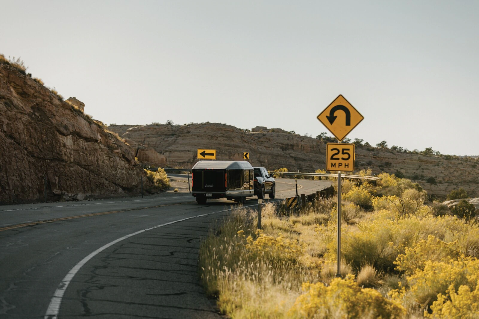 Lightship trailer traveling through a winding desert road.