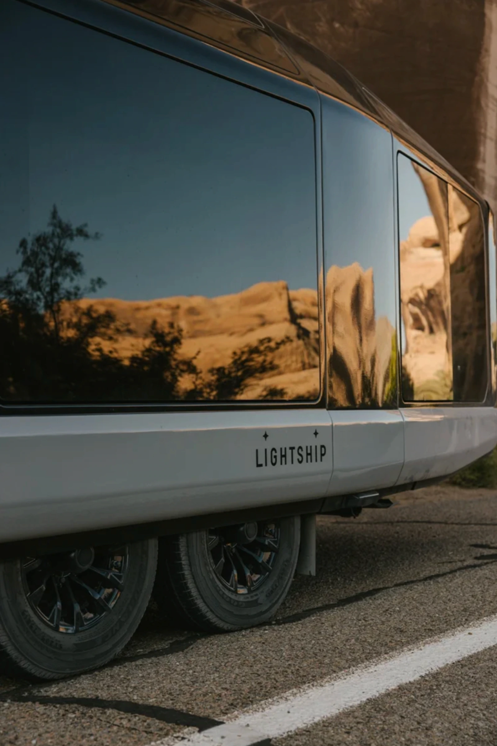 Reflective exterior detail of the Lightship trailer in a desert canyon setting.