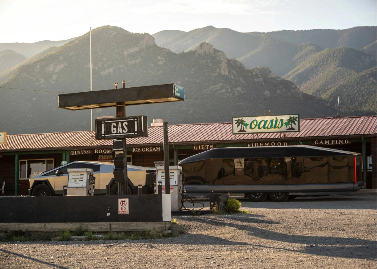 Lightship trailer and tow vehicle stopped at a vintage mountain gas station.