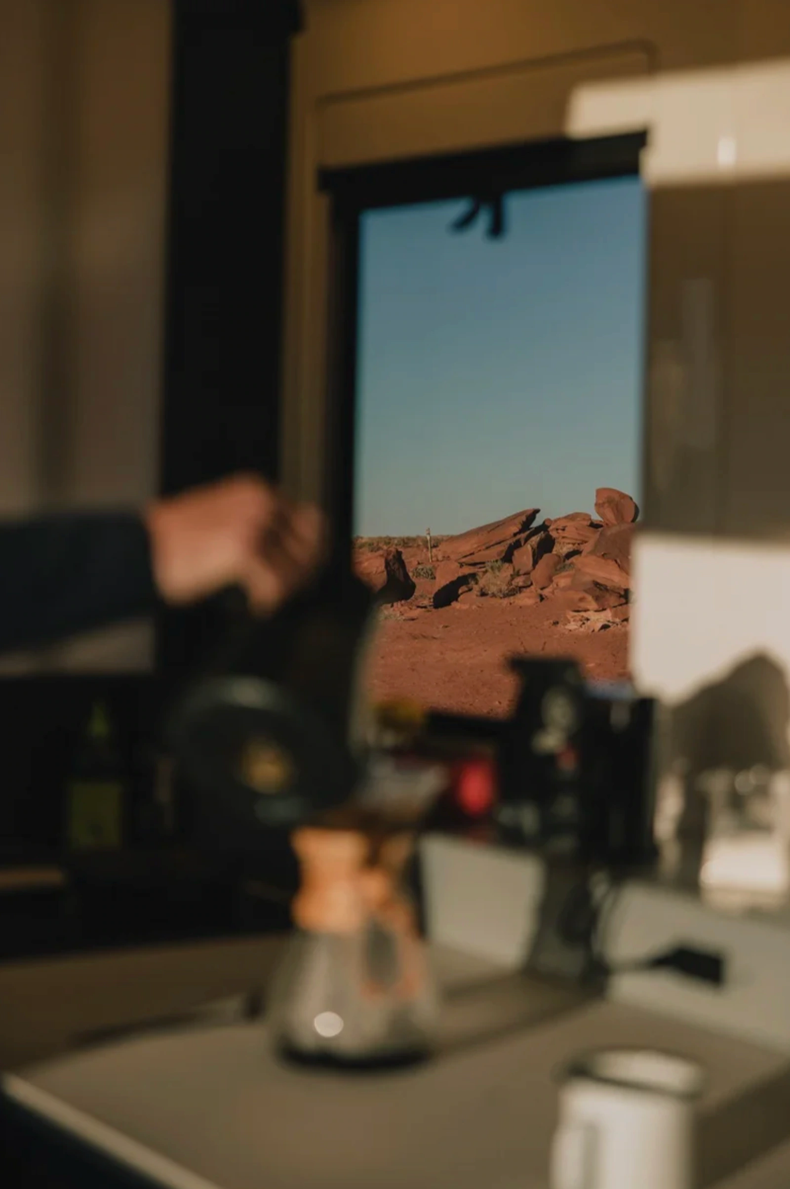 Soft-focus interior view from inside the Lightship trailer looking out to red desert rocks.