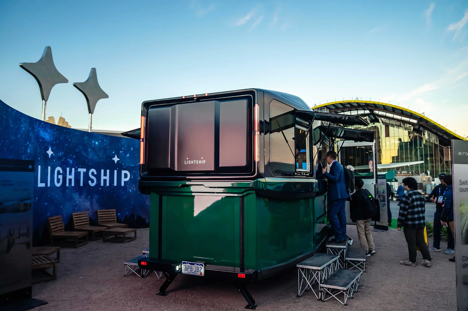 Rear three-quarter view of the Lightship trailer at CES showing the open exhibit setup and surrounding branded environment.