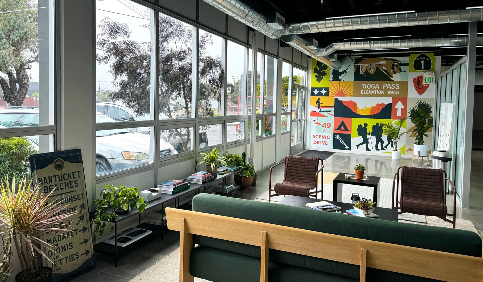 Lightship office lounge space with plants, seating and a colorful road-trip mural.