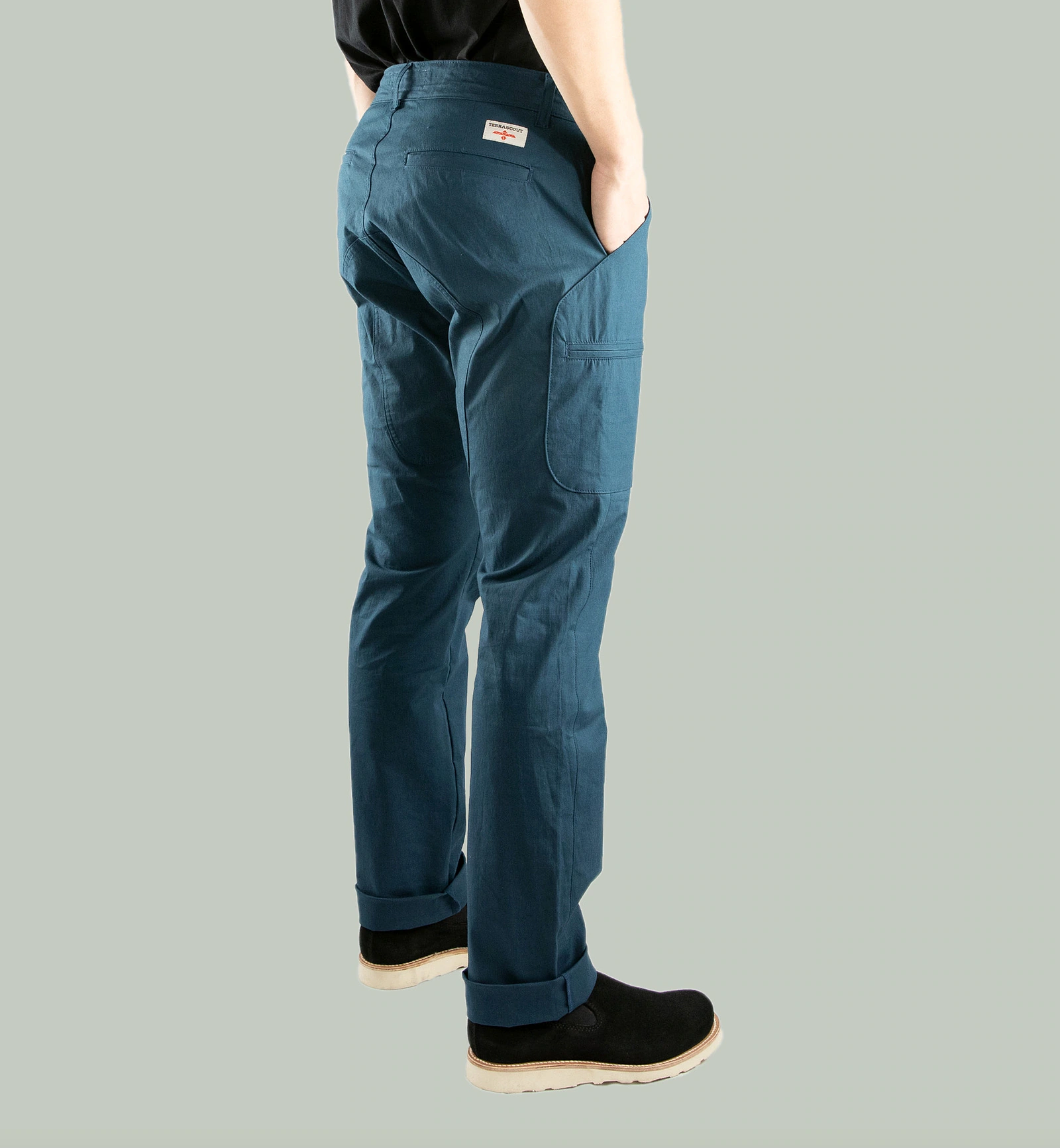 Rear three-quarter studio view of Terrascout blue utility pants showing back pocket, label and side cargo pocket.