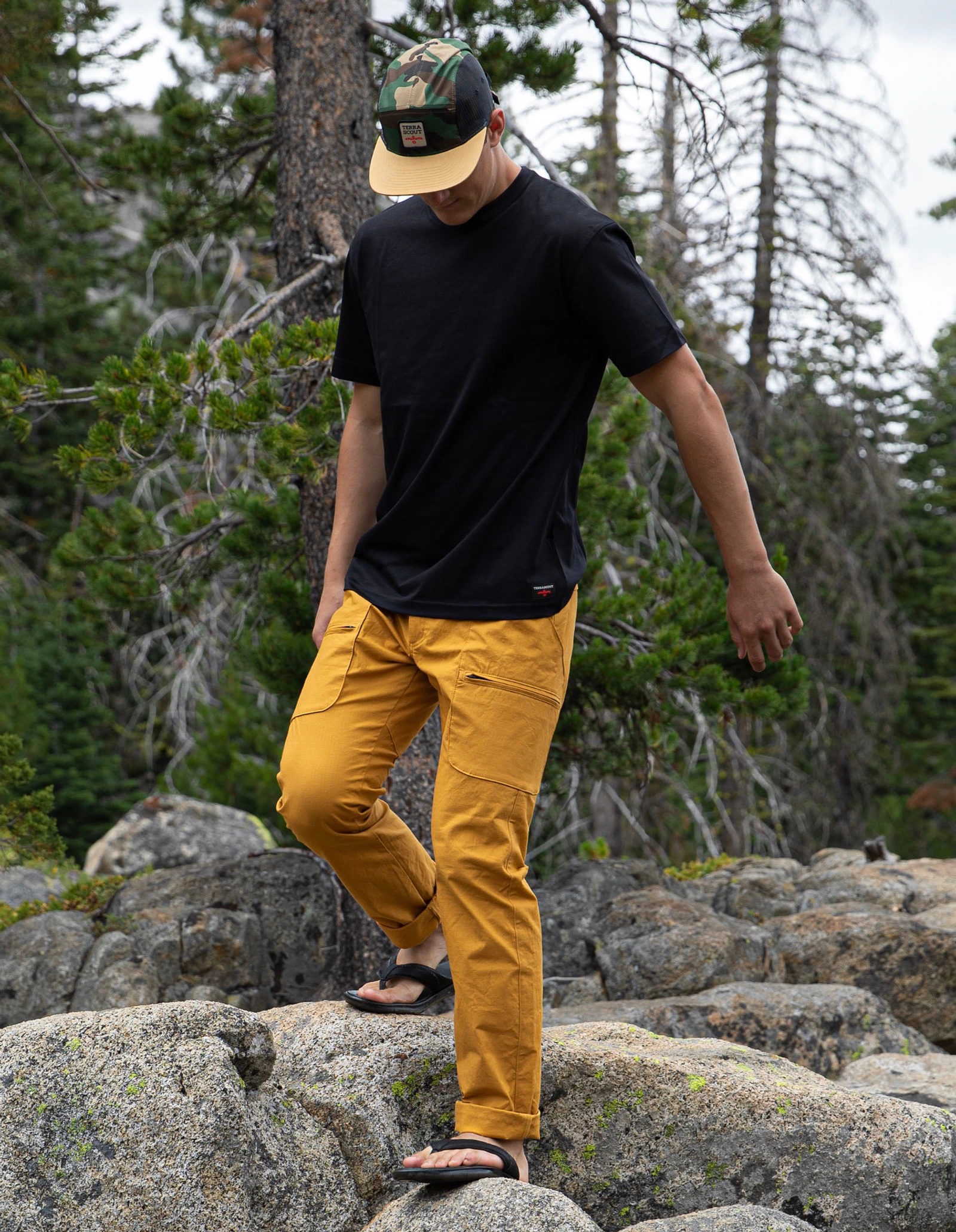 Terrascout mustard utility pant worn while moving across rocky alpine terrain.