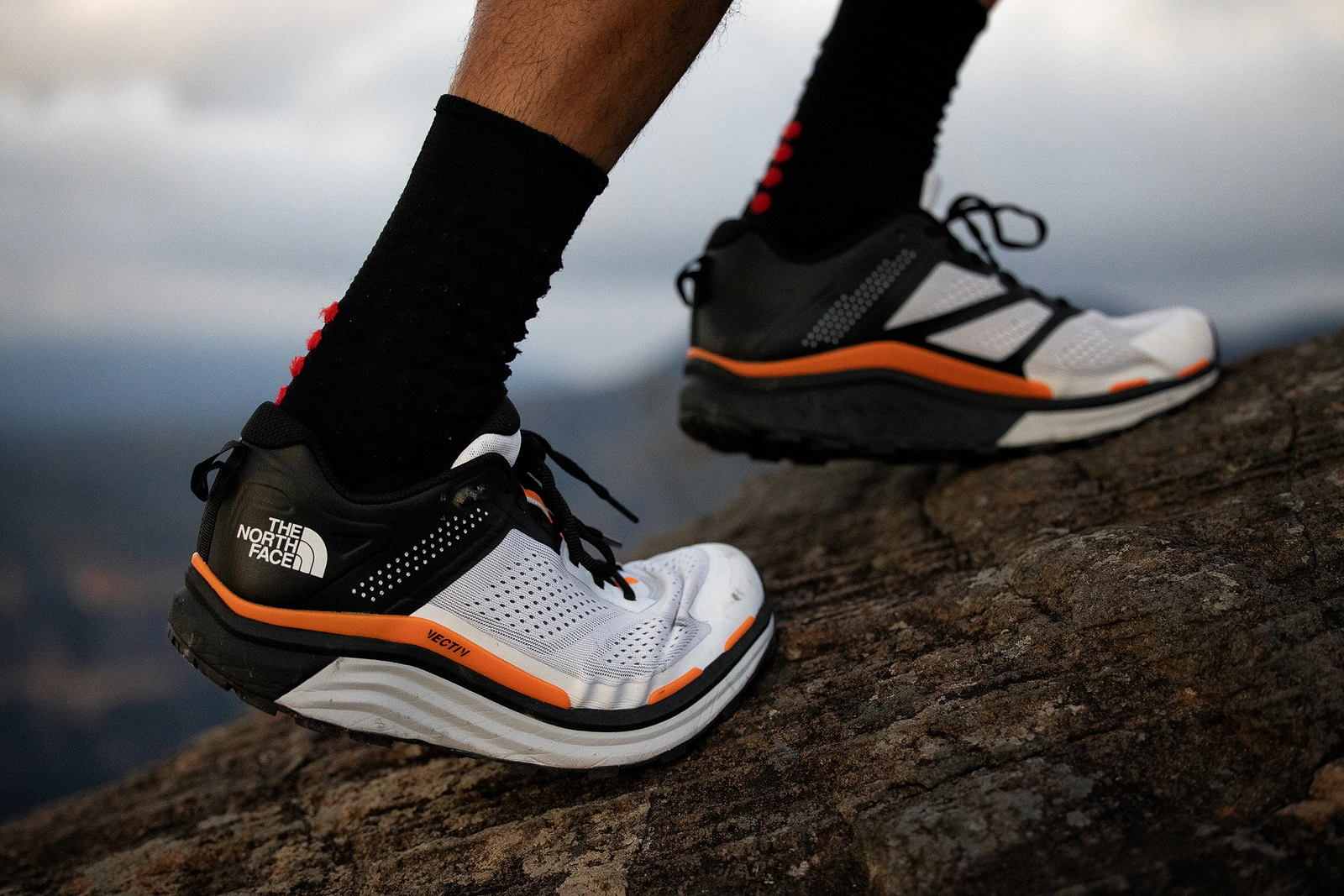 The North Face VECTIV performance shoes worn on rocky trail terrain.