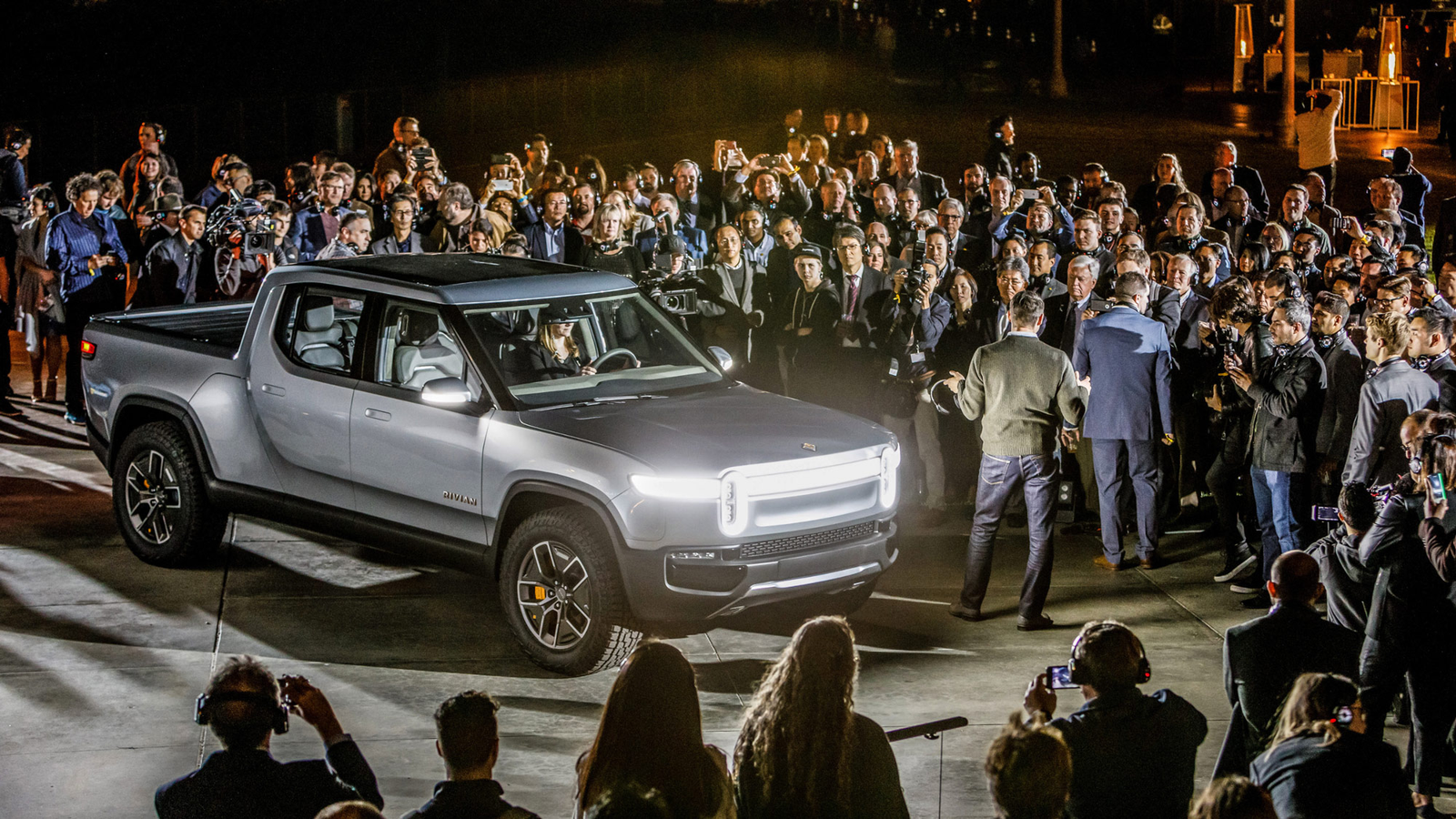 The silver Rivian R1T surrounded by guests at its nighttime premiere at Griffith Observatory.