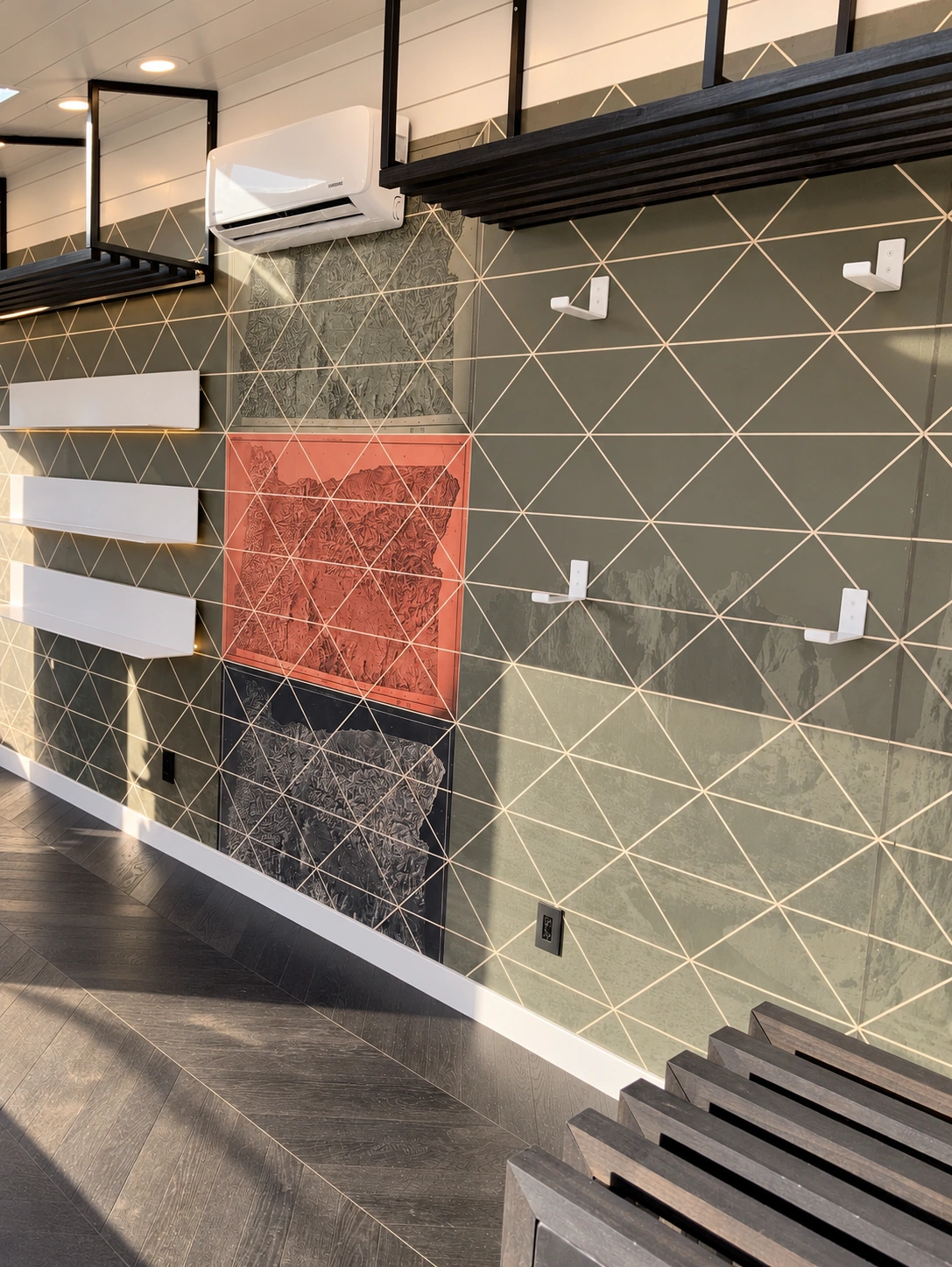 Interior development detail showing olive, coral and charcoal map graphics crossed by triangular lines, with empty wall hooks and footwear shelves.